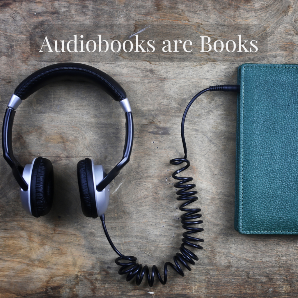 Headphones plugged into a book with the words "Audiobooks are books"